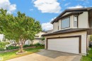Two-story residential exterior with light-colored siding, attached garage, and a concrete driveway - 1707 37A Avenue Nw, Edmonton, AB  - Outdoor 
