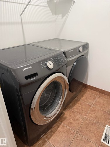 Tile flooring with a wire shelf - 1707 37A Avenue Nw, Edmonton, AB - Indoor Photo Showing Laundry Room