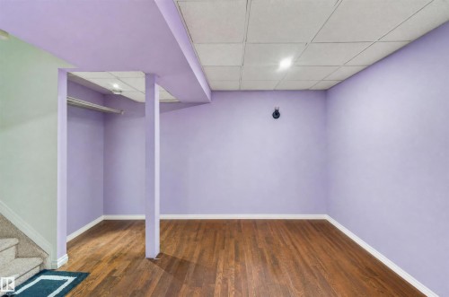 Wood-finish flooring with light purple walls - 1707 37A Avenue Nw, Edmonton, AB - Indoor Photo Showing Other Room