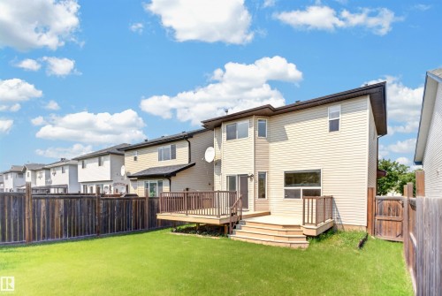 Expansive backyard featuring a manicured lawn, multi-level wood deck, privacy fence, and vinyl siding exterior - 1707 37A Avenue Nw, Edmonton, AB - Outdoor With Deck Patio Veranda