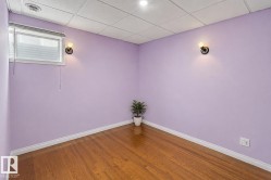Hardwood flooring, painted walls, wall-mounted light fixtures, and a drop ceiling - 