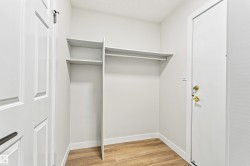 Wood-finish flooring, built-in shelving, and white paneled doors - 