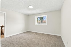 Wall-to-wall carpeting, white interior walls, overhead flush-mount lighting, and a window with white casing - 