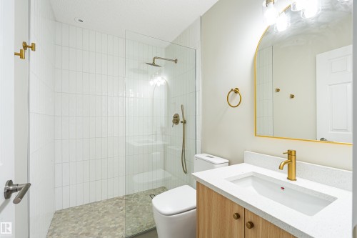 Glass-enclosed shower with subway tile surround and pebble-stone floor - #21 9375 172 St Nw, Edmonton, AB - Indoor Photo Showing Bathroom