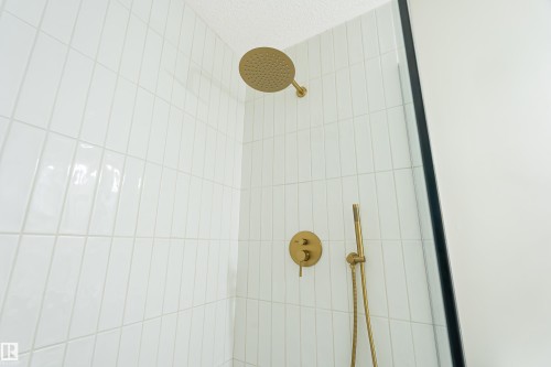 White subway tile shower enclosure with gold-finish fixtures - #21 9375 172 St Nw, Edmonton, AB - Indoor Photo Showing Bathroom