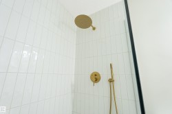 White subway tile shower enclosure with gold-finish fixtures - 