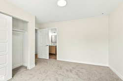 Plush carpeting, sliding closet doors, built-in closet shelving, overhead flush mount lighting, and a recessed ceiling light - 
