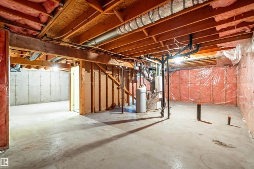 Unfinished basement with concrete flooring, exposed wood ceiling joists, and visible insulation - #21 9375 172 St Nw, Edmonton, AB - Indoor Photo Showing Basement