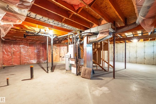 Unfinished basement featuring exposed wood joists, concrete foundation walls, and visible insulation - #21 9375 172 St Nw, Edmonton, AB - Indoor Photo Showing Basement
