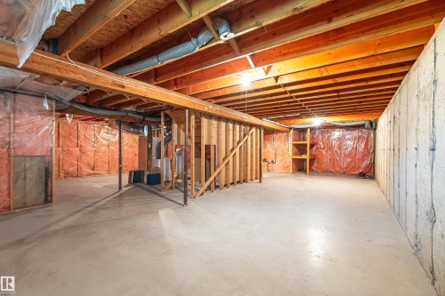 Unfinished basement featuring exposed wood joists, concrete flooring, and partial wall framing - #21 9375 172 St Nw, Edmonton, AB - Indoor Photo Showing Basement
