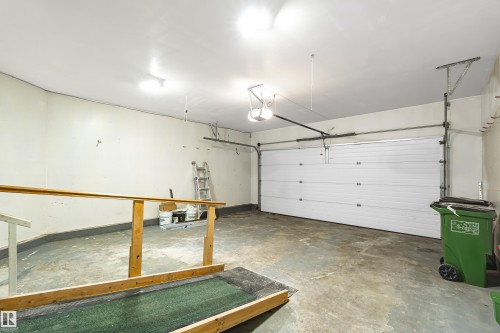 Attached garage with a white sectional door and overhead lighting - #21 9375 172 St Nw, Edmonton, AB - Indoor Photo Showing Garage
