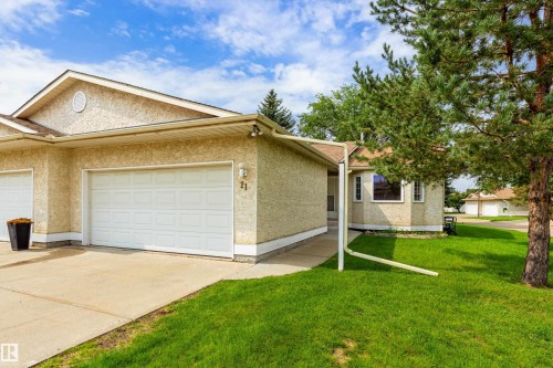 Attached garage with white panel door, stucco exterior, and gable roof - #21 9375 172 St Nw, Edmonton, AB - Outdoor