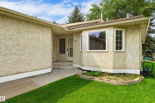 Stucco exterior with a bay window design, concrete pathway, and a landscaped garden bed - #21 9375 172 St Nw, Edmonton, AB - Outdoor
