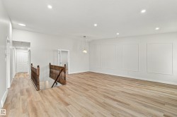Spacious interior featuring wood-finish flooring, recessed lighting, and decorative wall paneling - 