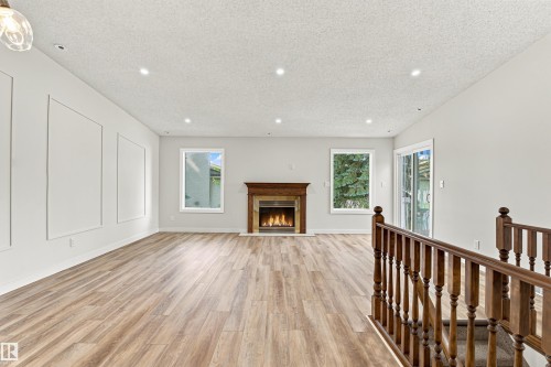Wood-finish flooring throughout, recessed lighting, and a fireplace with a wood mantle - #21 9375 172 St Nw, Edmonton, AB - Indoor With Fireplace