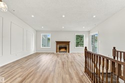 Wood-finish flooring throughout, recessed lighting, and a fireplace with a wood mantle - 