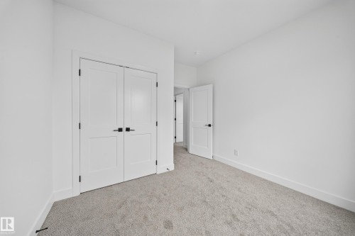 Light gray carpet, crisp white walls, white trim, and matte black hardware - 222 Black Stone Drive Drive, Leduc, AB - Indoor Photo Showing Other Room