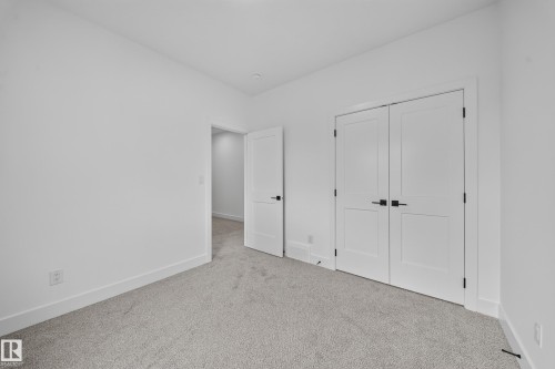 Neutral wall paint, plush carpet flooring, and white interior doors with dark hardware - 222 Black Stone Drive Drive, Leduc, AB - Indoor Photo Showing Other Room