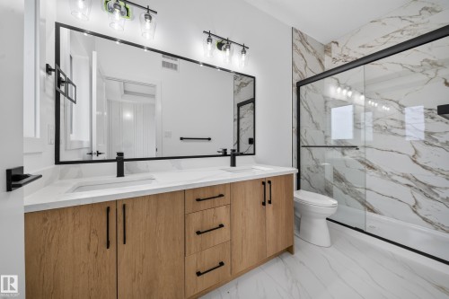 Double vanity with wood-finish cabinetry, white countertop, and integrated sinks - 222 Black Stone Drive Drive, Leduc, AB - Indoor Photo Showing Bathroom