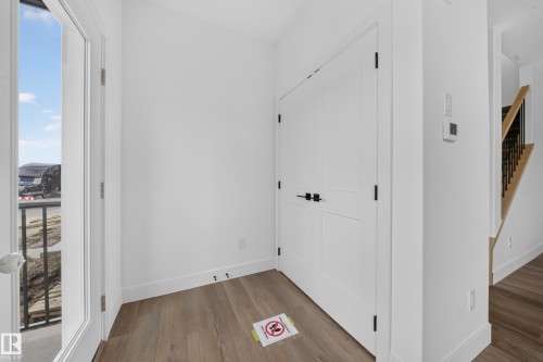 Wood-finish flooring, white walls, and a white interior door with black hardware - 222 Black Stone Drive Drive, Leduc, AB - Indoor Photo Showing Other Room