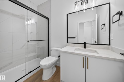 Modern bathroom featuring a single vanity with stone countertop, undermount sink, and matte black faucet - 222 Black Stone Drive Drive, Leduc, AB - Indoor Photo Showing Bathroom