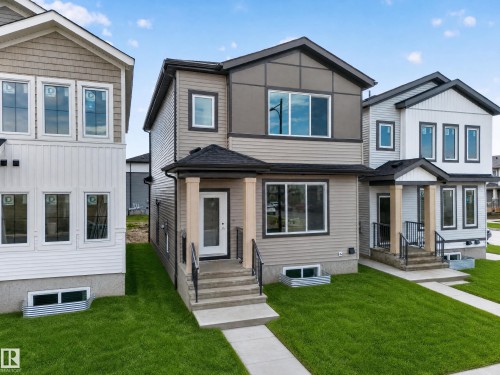 Contemporary architectural design with multi-tone siding, a covered front entry, and a prominent front door - 222 Black Stone Drive Drive, Leduc, AB - Outdoor With Facade