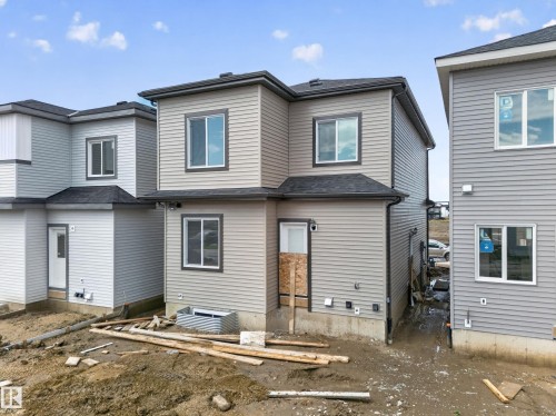 Two-story exterior with horizontal siding, dark window trim, dark roofing, and multiple windows - 222 Black Stone Drive Drive, Leduc, AB - Outdoor With Exterior