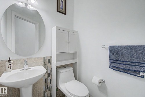 Pedestal sink with mosaic tile backsplash - 3236 21 Street Nw, Edmonton, AB - Indoor Photo Showing Bathroom