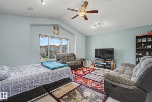 Vaulted ceiling with a ceiling fan, track lighting, and a large window - 3236 21 Street Nw, Edmonton, AB - Indoor Photo Showing Other Room