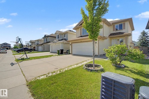 Two-story residence featuring a two-car garage, concrete driveway, and front lawn - 3236 21 Street Nw, Edmonton, AB - Outdoor