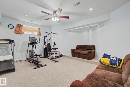 Recessed lighting and a ceiling fan illuminate a carpeted room with a high ceiling - 3236 21 Street Nw, Edmonton, AB - Indoor Photo Showing Gym Room