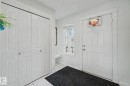 White paneled entry door with fluted trim, white window, and built-in bench - 3236 21 Street Nw, Edmonton, AB  - Indoor Photo Showing Other Room 