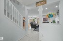White balustrade staircase, recessed lighting, tile flooring, and a half-wall architectural feature - 3236 21 Street Nw, Edmonton, AB  - Indoor Photo Showing Other Room 