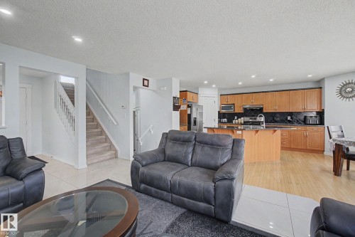 Open concept living space featuring recessed lighting and a kitchen with wood cabinetry - 3236 21 Street Nw, Edmonton, AB - Indoor Photo Showing Living Room