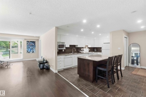 Open-concept living space with dark wood-finish flooring - #104 10221 111 St Nw, Edmonton, AB - Indoor