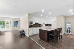 Open-concept living space with dark wood-finish flooring - 