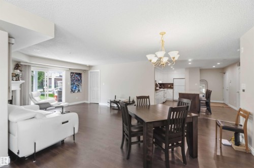 Open-concept living and dining area with wood-finish flooring, recessed lighting, and a chandelier - #104 10221 111 St Nw, Edmonton, AB - Indoor