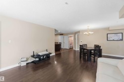 Expansive living area with wood-finish flooring, neutral wall tones, and recessed lighting - 