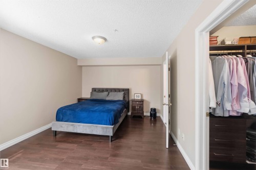 Wood-finish flooring, recessed lighting, and a built-in closet with shelving and drawers - #104 10221 111 St Nw, Edmonton, AB - Indoor Photo Showing Bedroom
