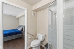 Corner shower enclosure with frosted glass panels and a white toilet - 