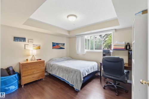 Recessed ceiling detail and a central flush-mount light fixture - #104 10221 111 St Nw, Edmonton, AB - Indoor Photo Showing Bedroom