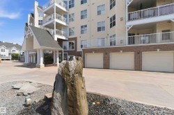 Multi-story building featuring a covered portico entry, multiple balconies with white railings, a brick facade base, and integrated garage doors - 