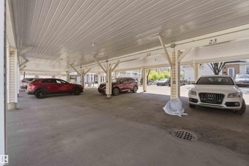 Covered parking structure with individual numbered spaces and a concrete surface - #104 10221 111 St Nw, Edmonton, AB -  Photo Showing Garage