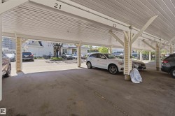 Covered carport featuring concrete flooring, exposed beam construction with corrugated metal roof, and structural support columns - 