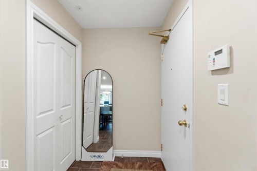 Entryway featuring bi-fold closet doors, a security panel, and a tiled floor - #104 10221 111 St Nw, Edmonton, AB - Indoor Photo Showing Other Room