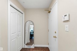 Entryway featuring bi-fold closet doors, a security panel, and a tiled floor - 