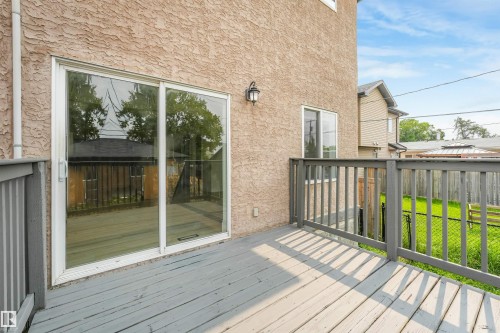 Expansive outdoor deck with gray wood-finish railings, textured stucco exterior, and sliding glass doors - 10234 155 Street Nw, Edmonton, AB - Outdoor With Deck Patio Veranda With Exterior