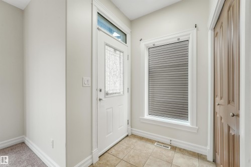 Entryway featuring a white paneled door with decorative glass, transom window, and tile flooring - 10234 155 Street Nw, Edmonton, AB - Indoor Photo Showing Other Room