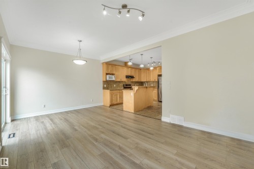 Wood-finish flooring, crown molding, and sliding glass door - 10234 155 Street Nw, Edmonton, AB - Indoor Photo Showing Kitchen