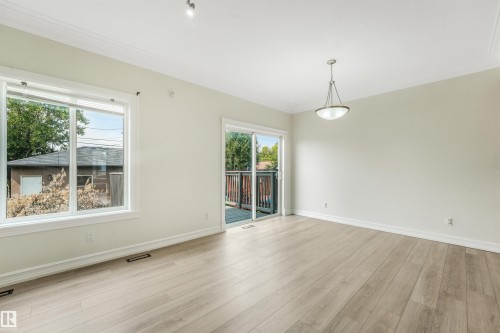 Light wood-finish flooring, crown molding, track lighting, and a pendant light fixture - 10234 155 Street Nw, Edmonton, AB - Indoor